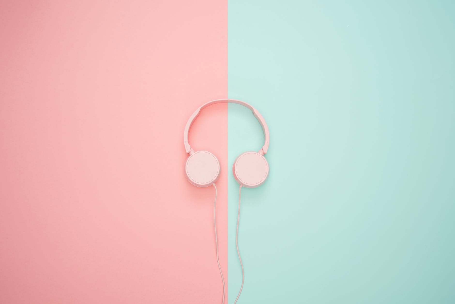 pink corded headphones on pink and teal wall